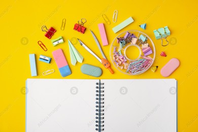 Flat lay composition with notebook and different school stationery on yellow background. Back to school Photo of Flat lay composition with notebook and different school stationery on yellow background. Back to school
