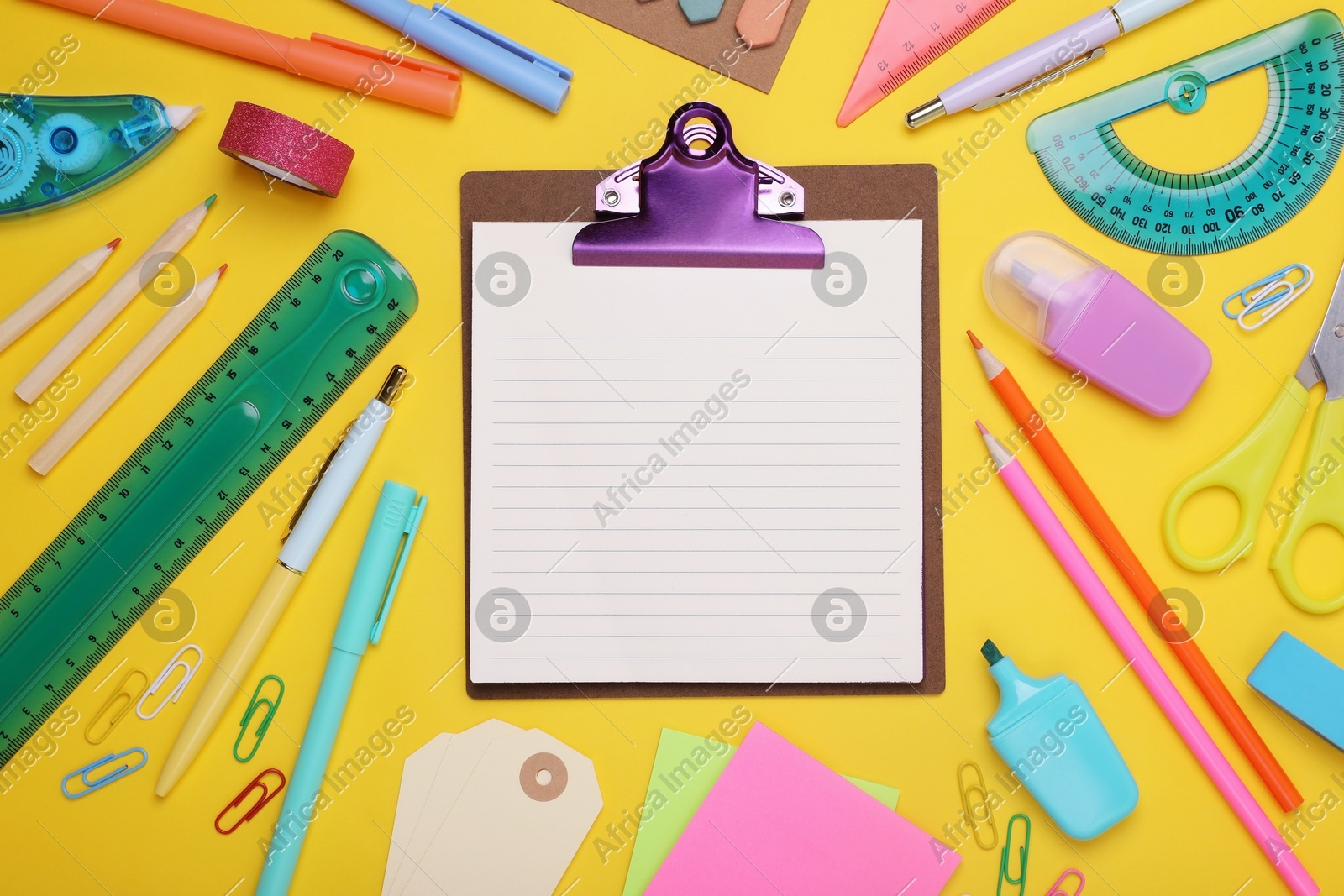Flat lay composition of clipboard with notes and other school stationery on yellow background, space for text. Back to school Photo of Flat lay composition of clipboard with notes and other school stationery on yellow background, space for text. Back to school