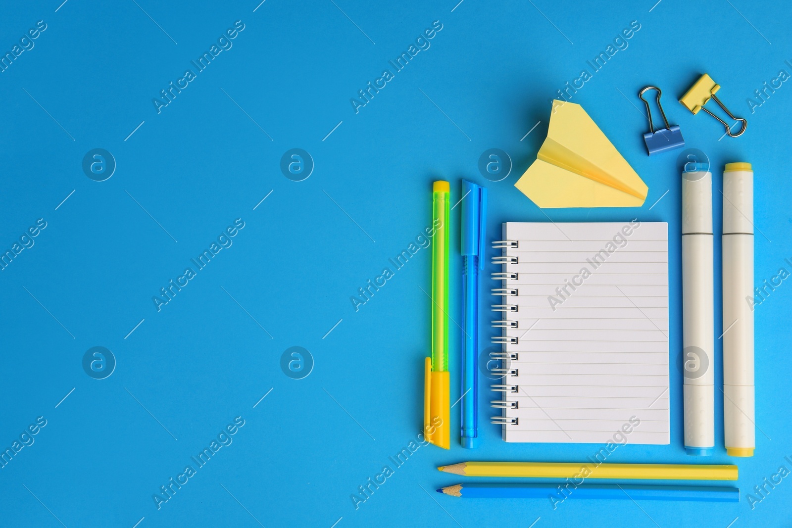 Paper plane and different school stationery on light blue background, flat lay with space for text. Back to school Photo of Paper plane and different school stationery on light blue background, flat lay with space for text. Back to school
