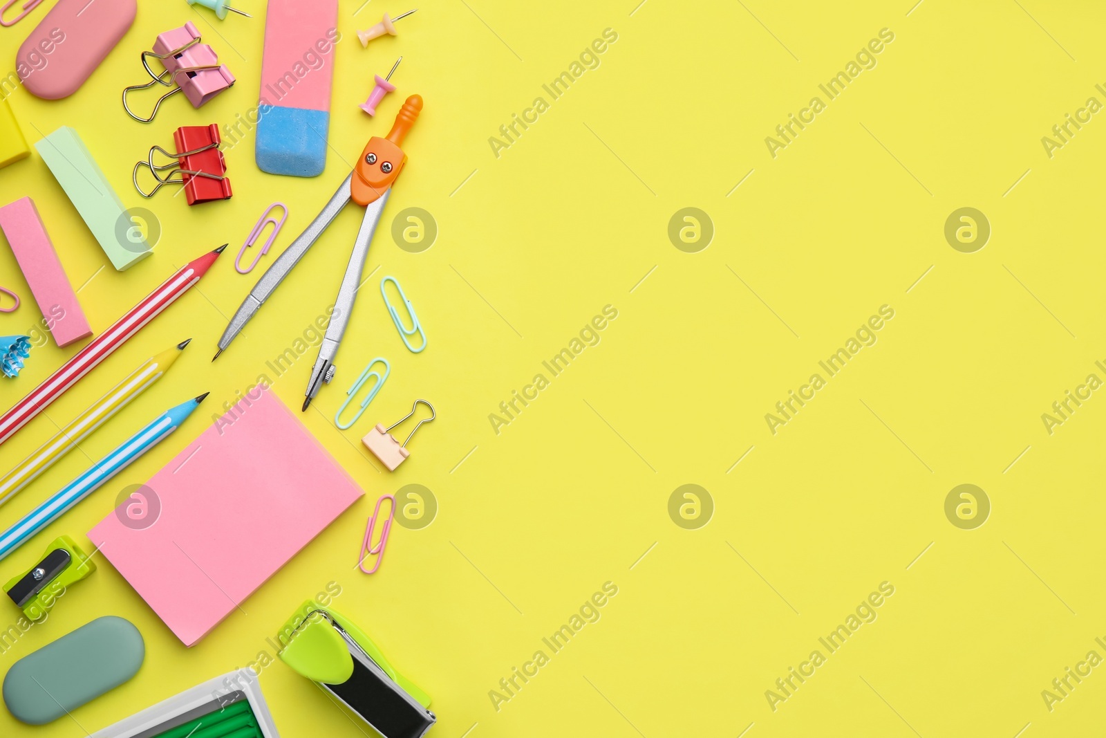 Flat lay composition with different school stationery on pale yellow background, space for text. Back to school Photo of Flat lay composition with different school stationery on pale yellow background, space for text. Back to school