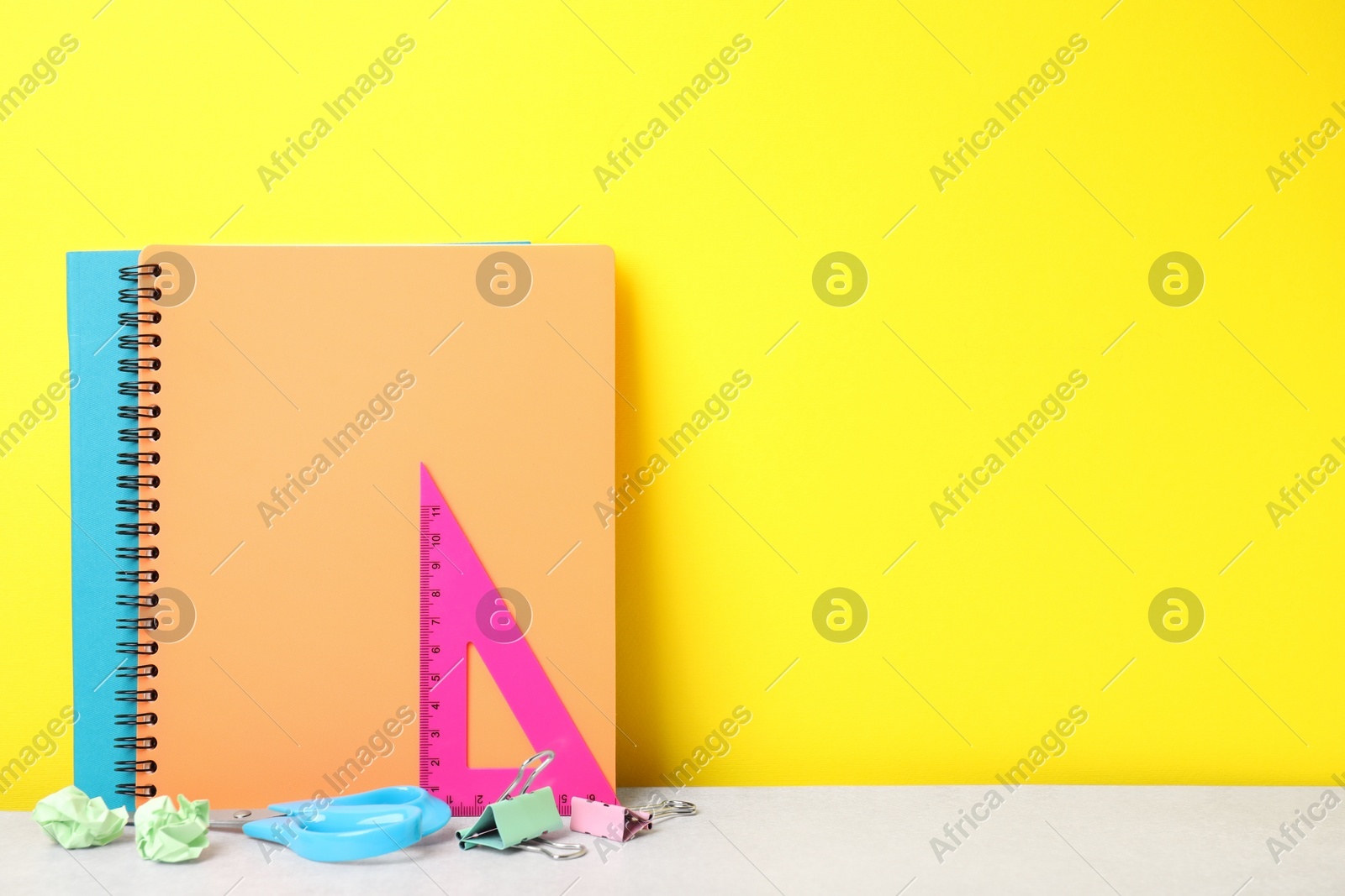 Different school stationery on white table against yellow background, space for text. Back to school Photo of Different school stationery on white table against yellow background, space for text. Back to school