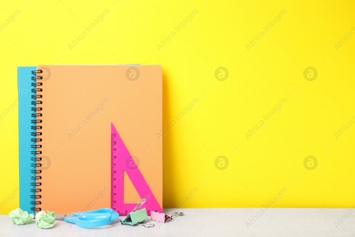 Different school stationery on white table against yellow background, space for text. Back to school Photo of Different school stationery on white table against yellow background, space for text. Back to school