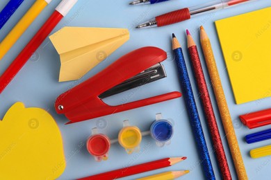 Flat lay composition with sticky note and other school stationery on light blue background, space for text. Back to school Photo of Flat lay composition with sticky note and other school stationery on light blue background, space for text. Back to school