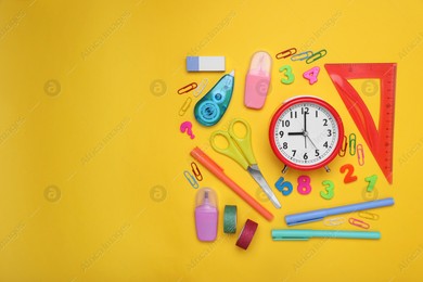 Flat lay composition with different school stationery and alarm clock on yellow background, space for text. Back to school Photo of Flat lay composition with different school stationery and alarm clock on yellow background, space for text. Back to school