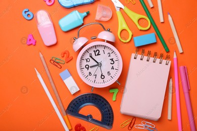 Flat lay composition with different school stationery and alarm clock on red background, space for text. Back to school Photo of Flat lay composition with different school stationery and alarm clock on red background, space for text. Back to school