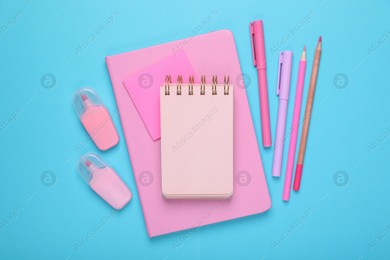 Flat lay composition with pink notebooks and other school stationery on light blue background, space for text. Back to school Photo of Flat lay composition with pink notebooks and other school stationery on light blue background, space for text. Back to school