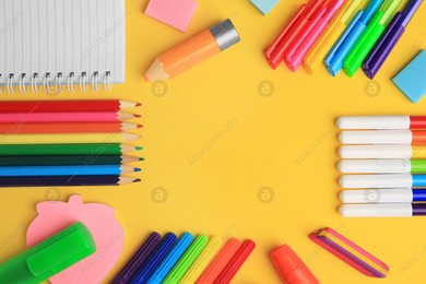 Frame made of different school stationery on yellow background, flat lay and space for text. Back to school Photo of Frame made of different school stationery on yellow background, flat lay and space for text. Back to school