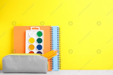 Different school stationery on white table against yellow background, space for text. Back to school Photo of Different school stationery on white table against yellow background, space for text. Back to school