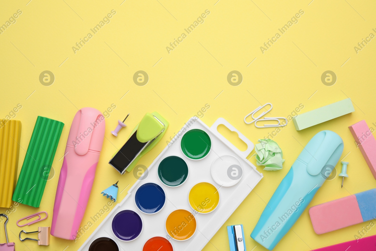 Flat lay composition with different school stationery on pale yellow background, space for text. Back to school Photo of Flat lay composition with different school stationery on pale yellow background, space for text. Back to school