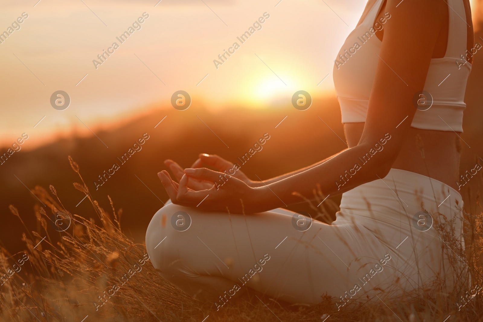Woman meditating outdoors at sunset, closeup view Photo of Woman meditating outdoors at sunset, closeup view