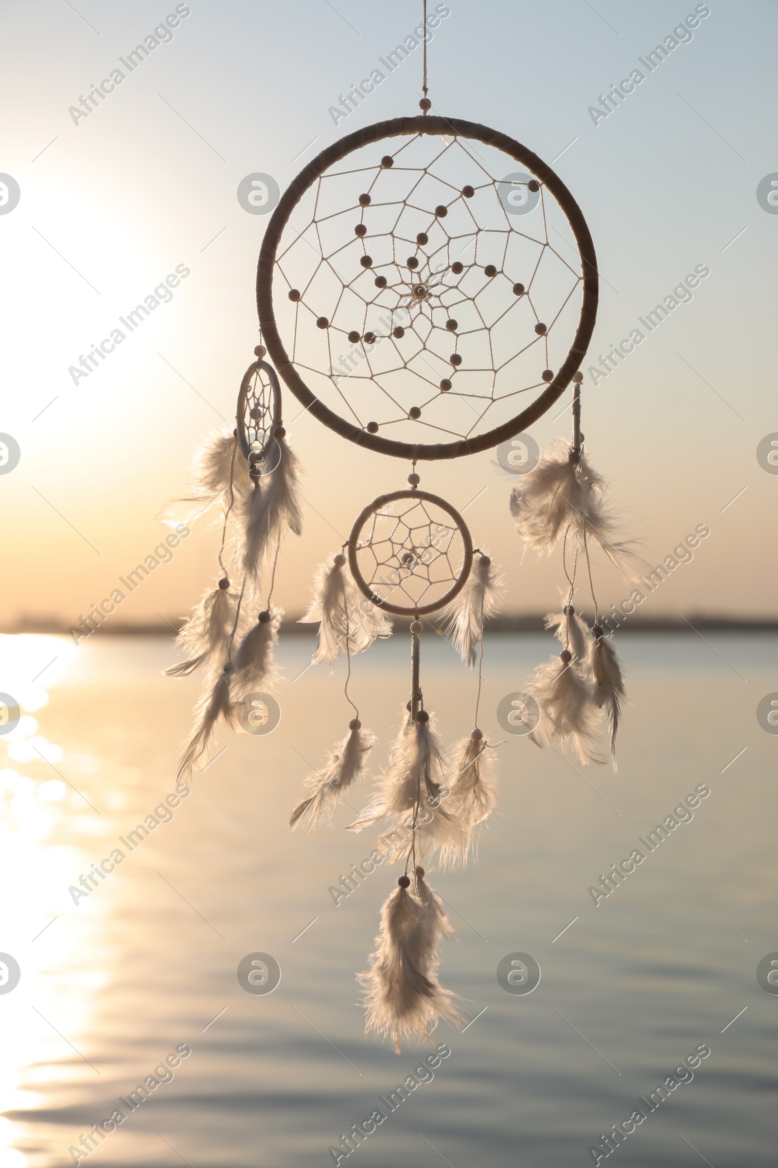Beautiful handmade dream catcher near river at sunset Photo of Beautiful handmade dream catcher near river at sunset