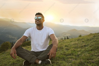 Handsome man enjoying beautiful mountain landscape at sunset Photo of Handsome man enjoying beautiful mountain landscape at sunset