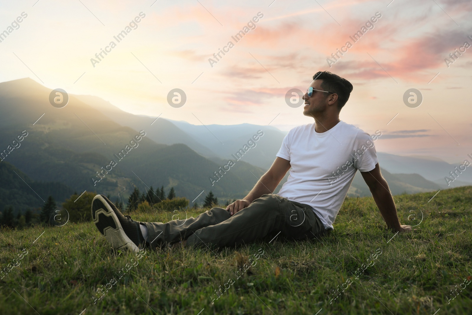Handsome man enjoying beautiful mountain landscape at sunset Photo of Handsome man enjoying beautiful mountain landscape at sunset