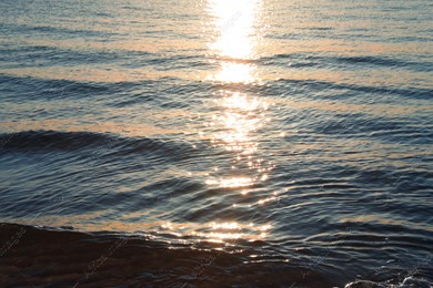 Rippled surface of sea at sunset as background Photo of Rippled surface of sea at sunset as background