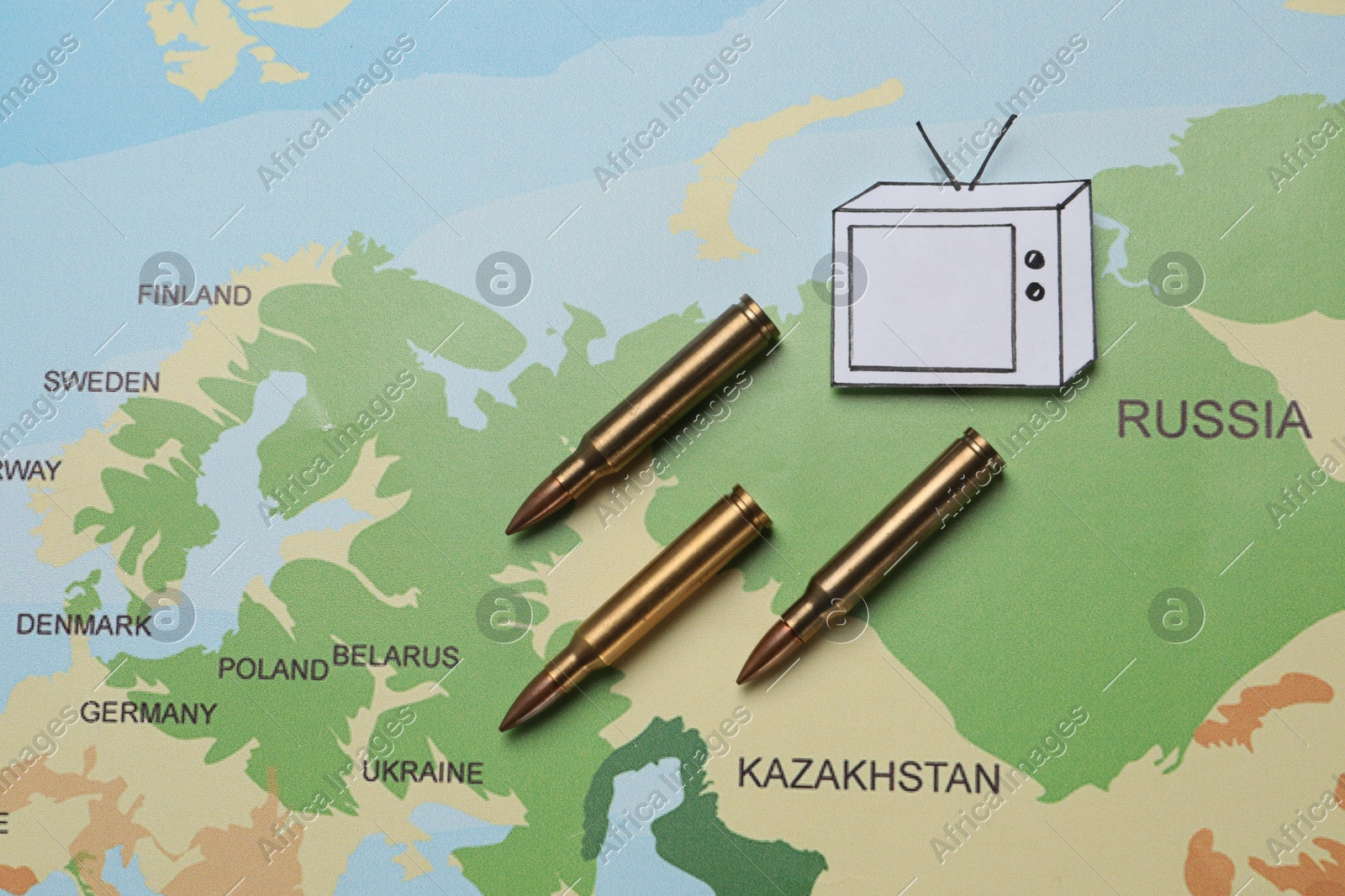 Paper TV and bullets on world map, flat lay. Hybrid warfare concept Photo of Paper TV and bullets on world map, flat lay. Hybrid warfare concept
