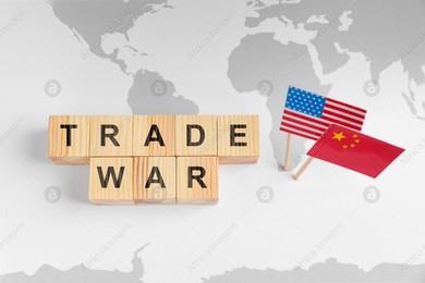 Words Trade War made of wooden cubes, American and Chinese flags on world map, above view Photo of Words Trade War made of wooden cubes, American and Chinese flags on world map, above view