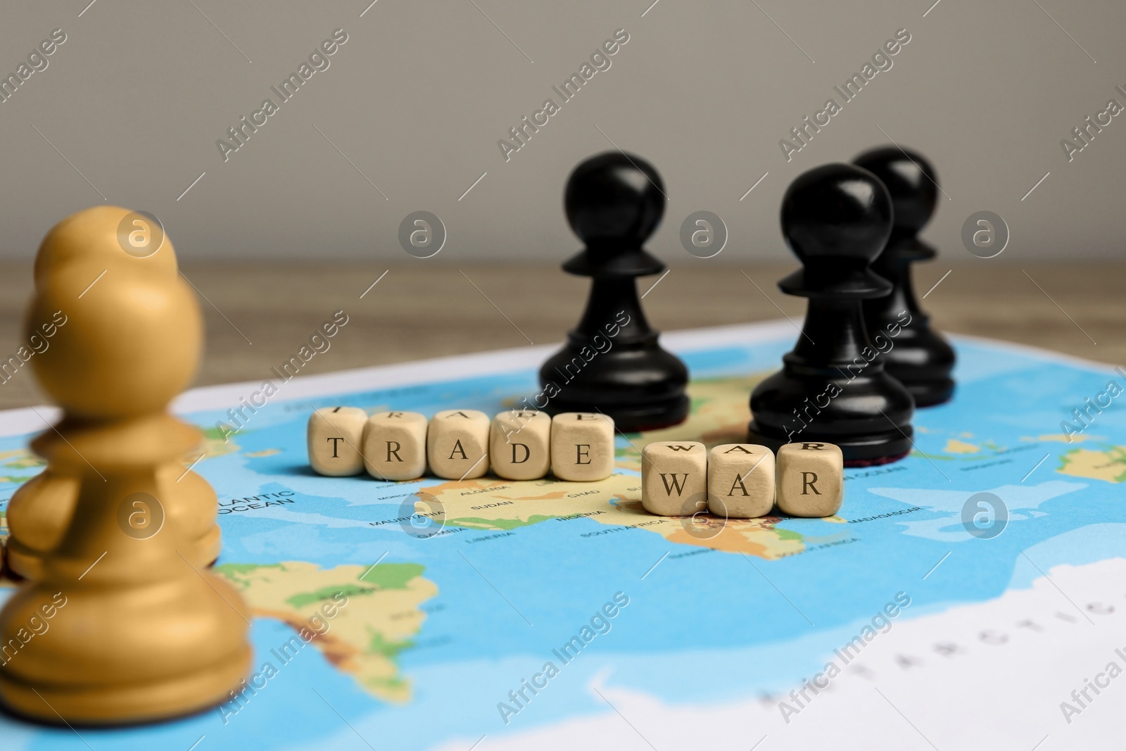 Phrase Trade war made with cubes, chess pieces and world map on wooden table, closeup Photo of Phrase Trade war made with cubes, chess pieces and world map on wooden table, closeup