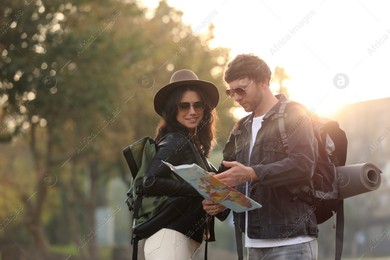 Couple of travelers with map on city street Photo of Couple of travelers with map on city street