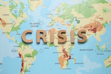 Word Crisis made of wooden letters on world map, flat lay Photo of Word Crisis made of wooden letters on world map, flat lay