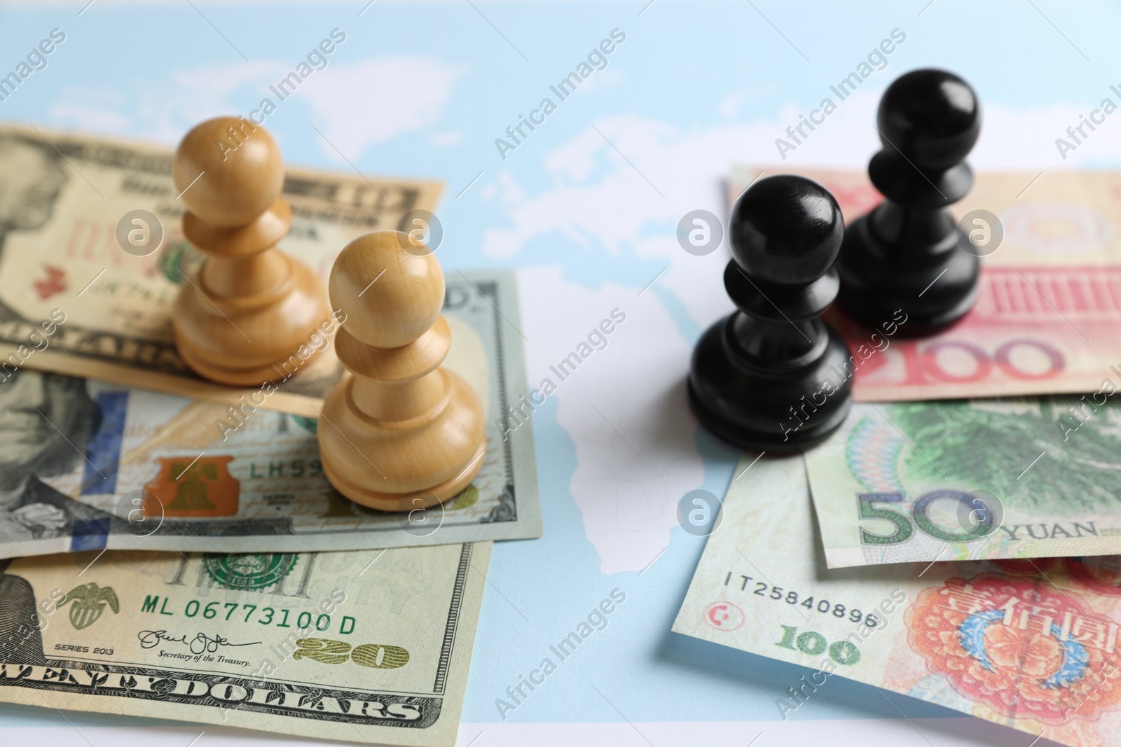 Chess pieces, yuan and dollar banknotes on world map. Trade war concept Photo of Chess pieces, yuan and dollar banknotes on world map. Trade war concept