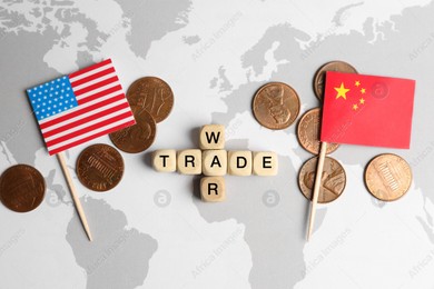 Phrase Trade war made with wooden cubes, coins near USA and China flags on world map, flat lay Photo of Phrase Trade war made with wooden cubes, coins near USA and China flags on world map, flat lay