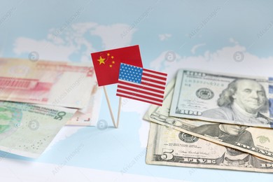 Banknotes, American and Chinese flags on world map. Trade war concept Photo of Banknotes, American and Chinese flags on world map. Trade war concept