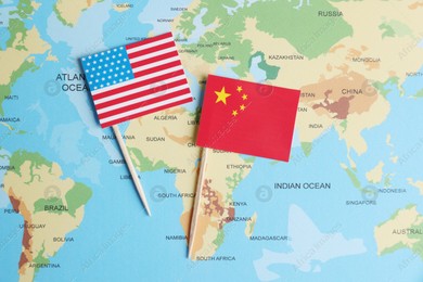American and Chinese flags on world map, top view. Trade war concept Photo of American and Chinese flags on world map, top view. Trade war concept