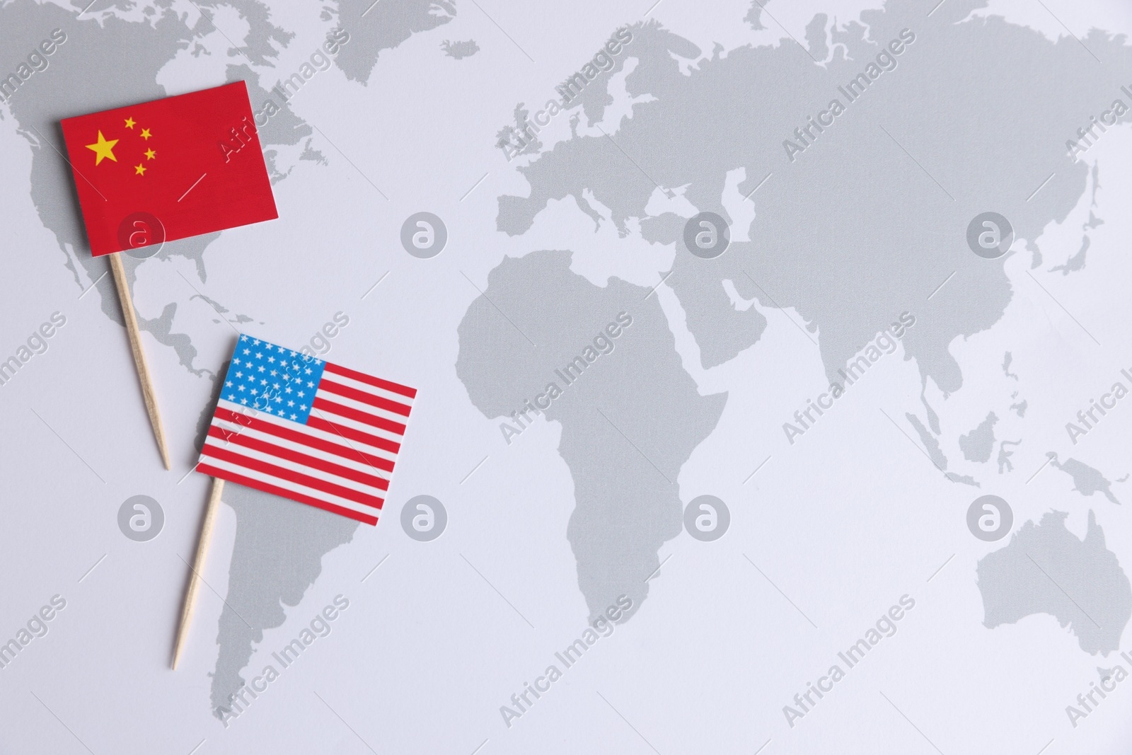 American and Chinese flags on world map, top view with space for text. Trade war concept Photo of American and Chinese flags on world map, top view with space for text. Trade war concept