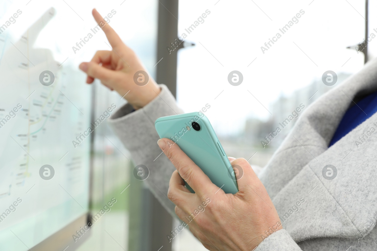 Woman with smartphone studying public transport map outdoors, closeup Photo of Woman with smartphone studying public transport map outdoors, closeup