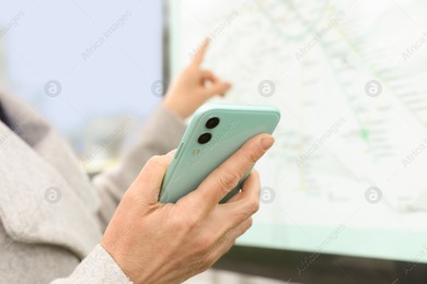 Woman with smartphone studying public transport map outdoors, closeup Photo of Woman with smartphone studying public transport map outdoors, closeup