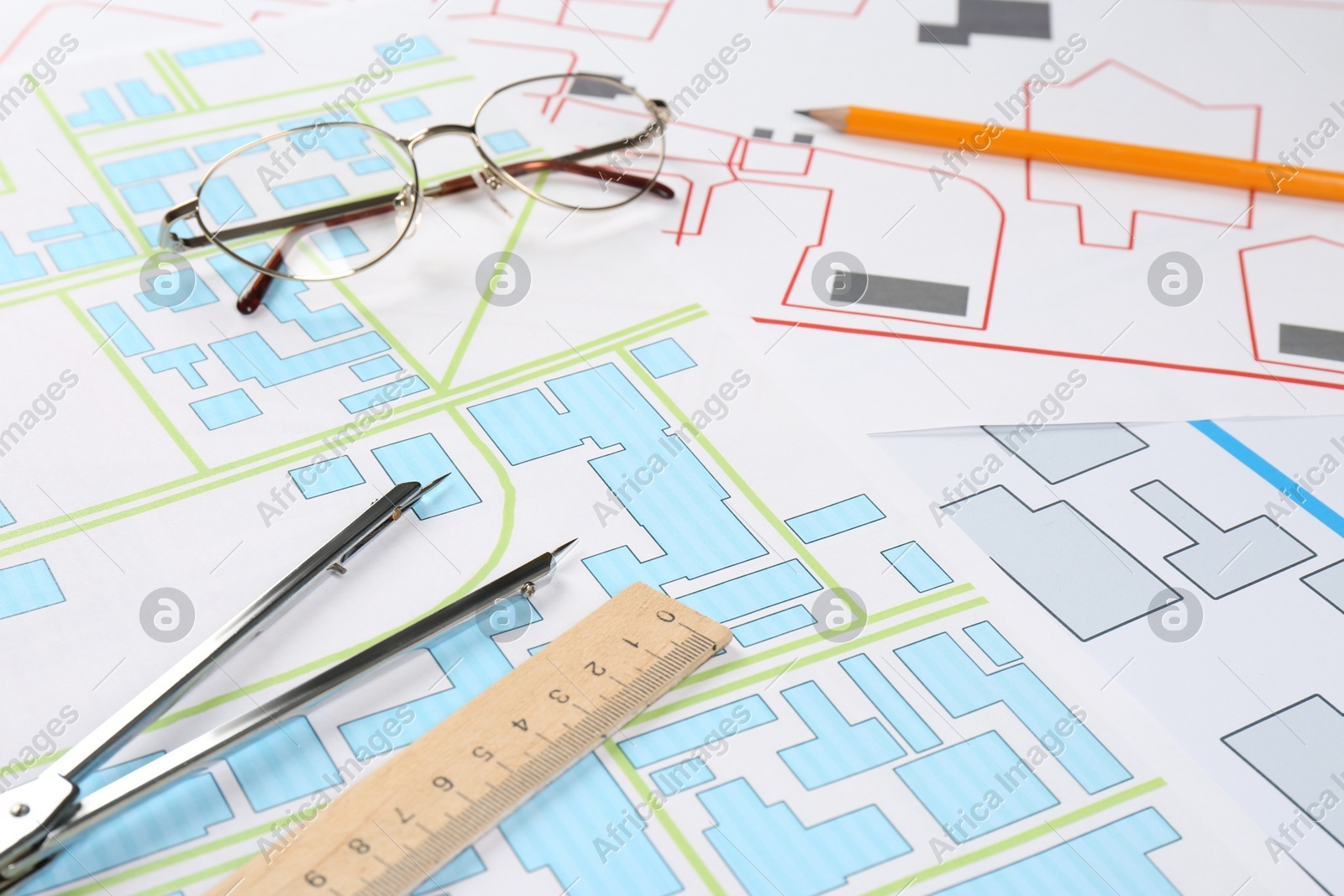Office stationery and eyeglasses on cadastral maps of territory with buildings Photo of Office stationery and eyeglasses on cadastral maps of territory with buildings