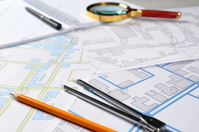 Office stationery and cadastral maps of territory with buildings on table Photo of Office stationery and cadastral maps of territory with buildings on table