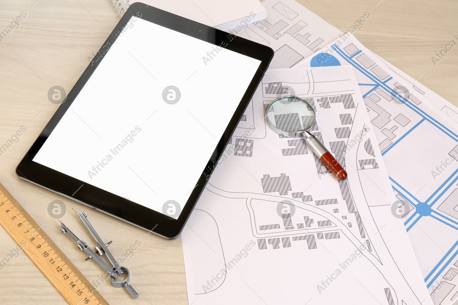 Office stationery, tablet and cadastral maps of territory with buildings on white wooden table Photo of Office stationery, tablet and cadastral maps of territory with buildings on white wooden table