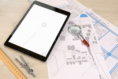 Office stationery, tablet and cadastral maps of territory with buildings on white wooden table Photo of Office stationery, tablet and cadastral maps of territory with buildings on white wooden table