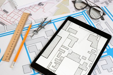 Office stationery, tablet and eyeglasses on cadastral maps of territory with buildings Photo of Office stationery, tablet and eyeglasses on cadastral maps of territory with buildings