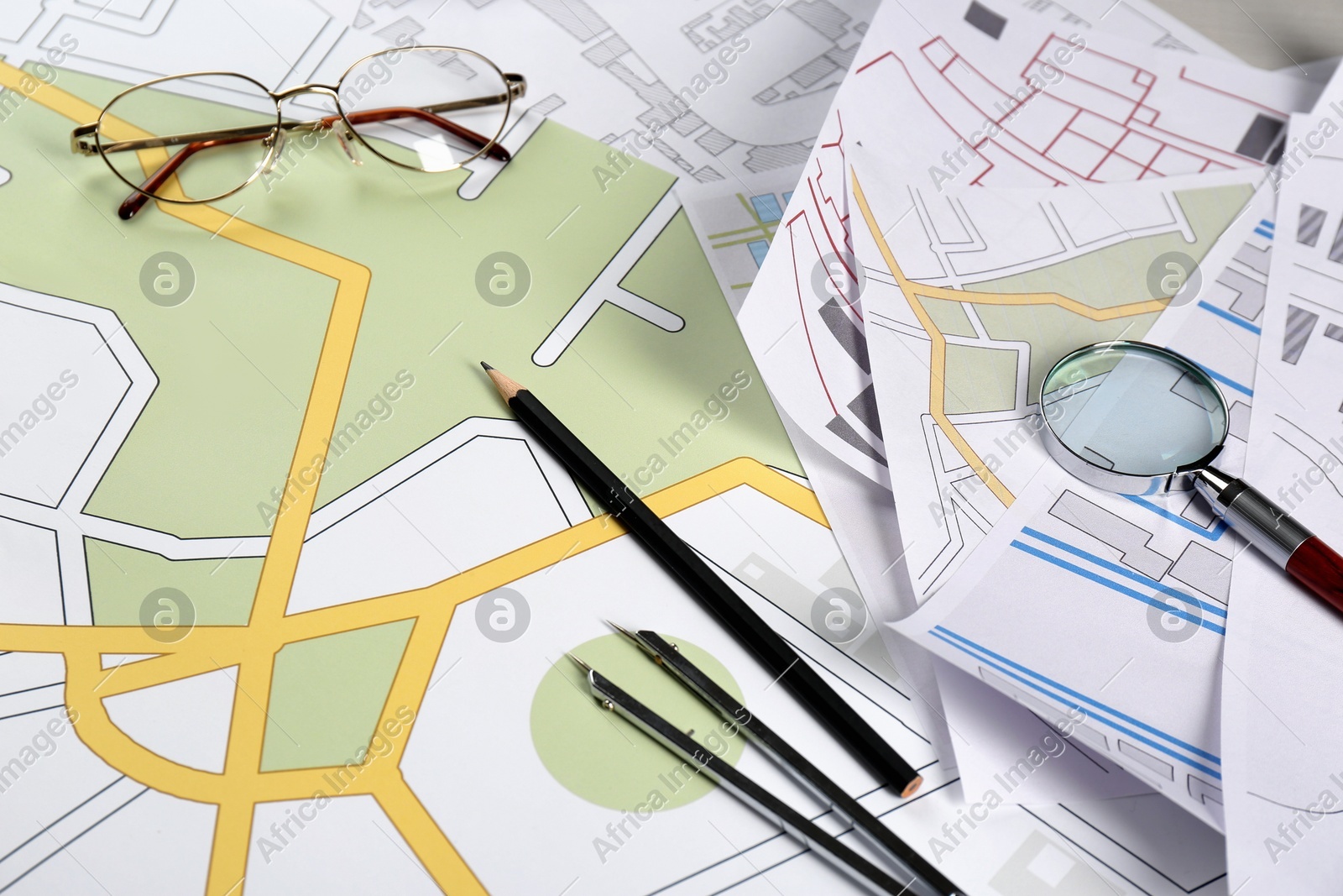 Office stationery and eyeglasses on cadastral maps of territory with buildings Photo of Office stationery and eyeglasses on cadastral maps of territory with buildings