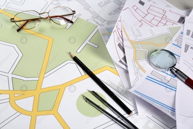 Office stationery and eyeglasses on cadastral maps of territory with buildings Photo of Office stationery and eyeglasses on cadastral maps of territory with buildings
