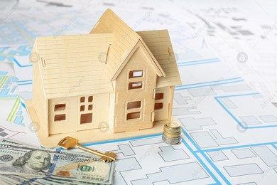 Money, key and house model on cadastral map Photo of Money, key and house model on cadastral map