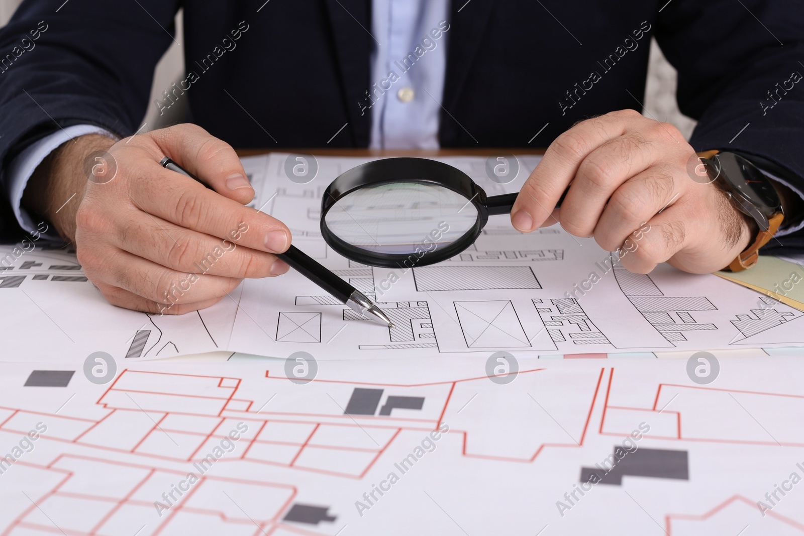 Professional cartographer working with cadastral map at table, closeup Photo of Professional cartographer working with cadastral map at table, closeup
