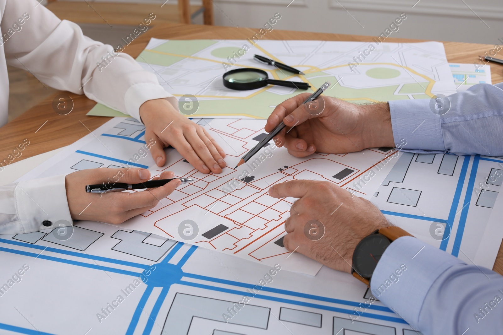 Professional cartographers working with cadastral map at table in office, closeup Photo of Professional cartographers working with cadastral map at table in office, closeup