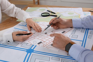 Professional cartographers working with cadastral map at table in office, closeup Photo of Professional cartographers working with cadastral map at table in office, closeup