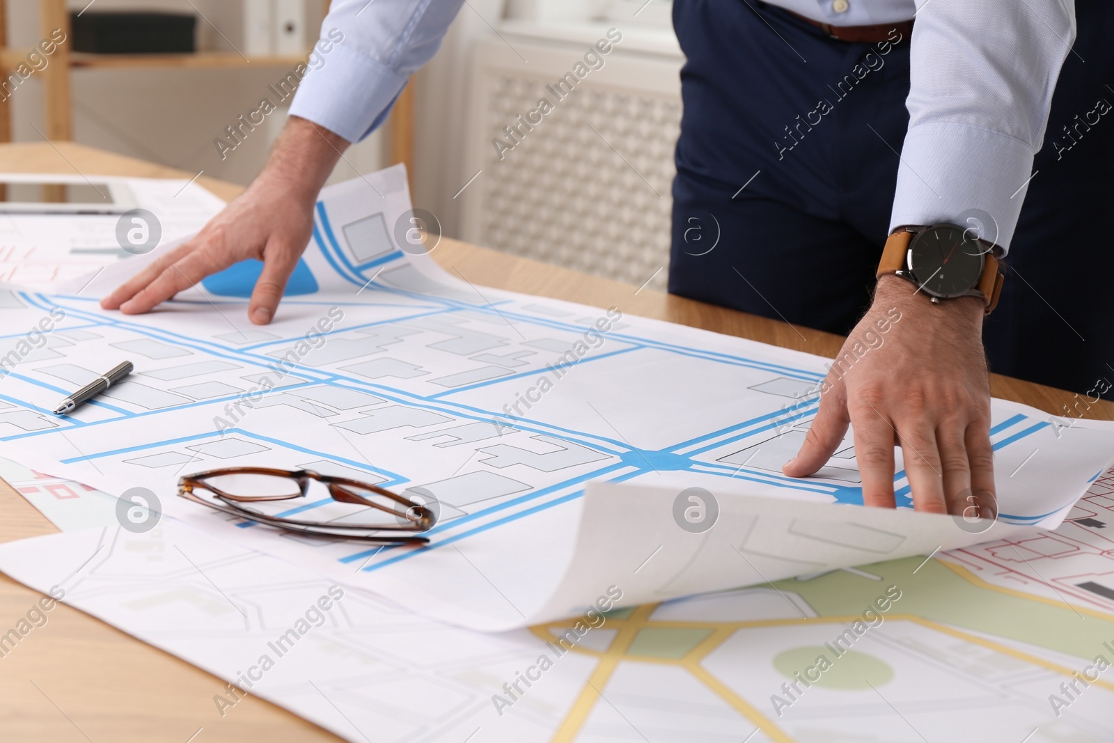 Professional cartographer working with cadastral map at table in office, closeup Photo of Professional cartographer working with cadastral map at table in office, closeup