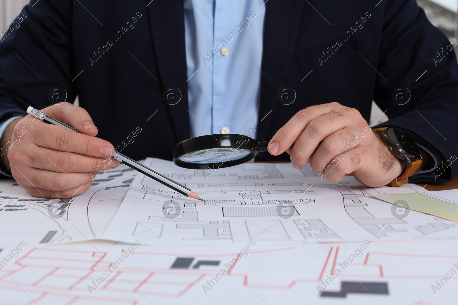 Professional cartographer working with cadastral map at table, closeup Photo of Professional cartographer working with cadastral map at table, closeup