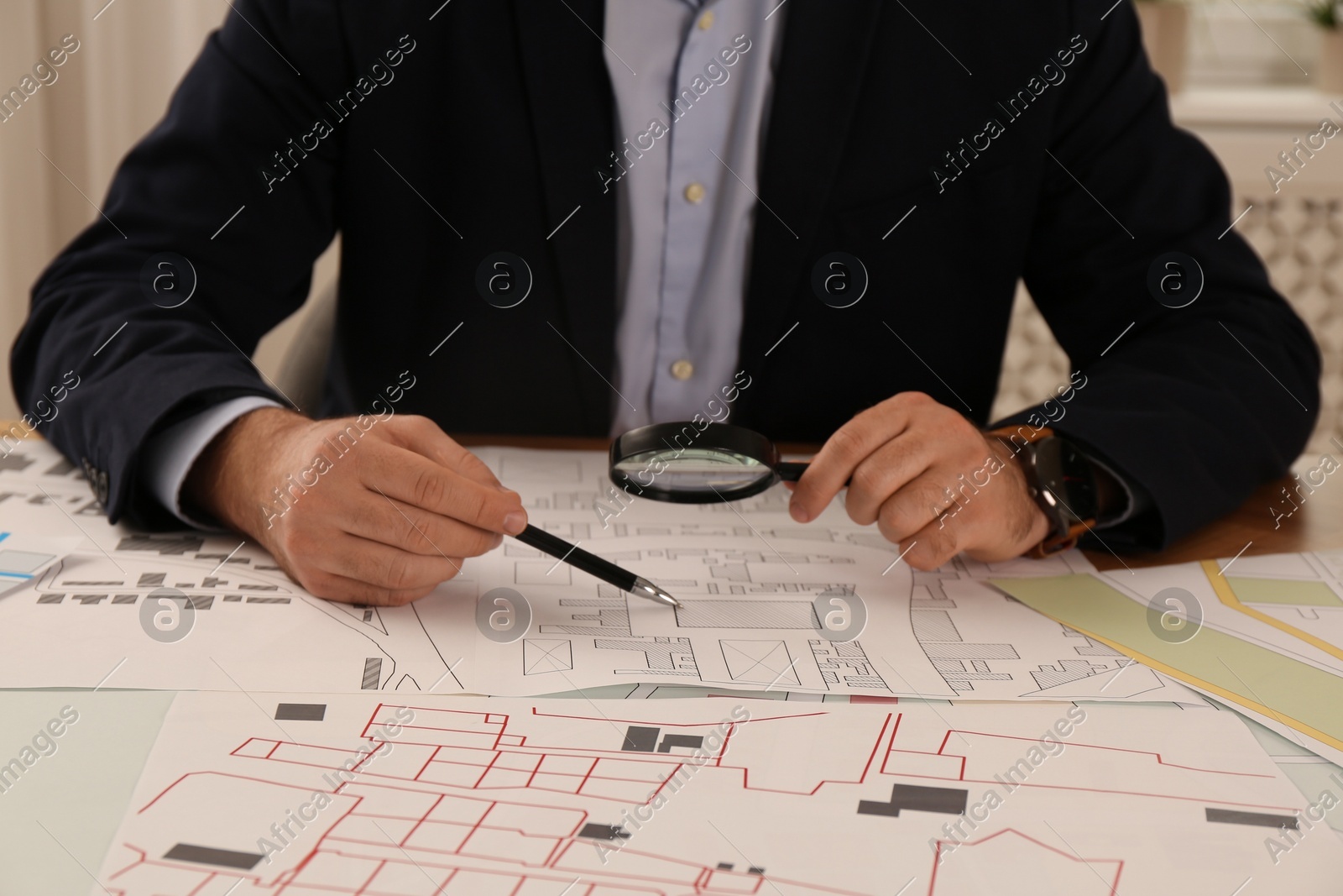 Professional cartographer working with cadastral map at table in office, closeup Photo of Professional cartographer working with cadastral map at table in office, closeup