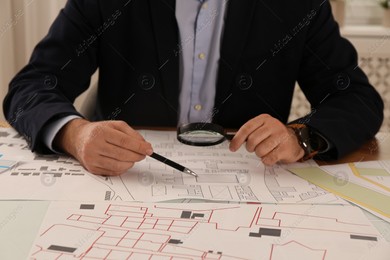 Professional cartographer working with cadastral map at table in office, closeup Photo of Professional cartographer working with cadastral map at table in office, closeup