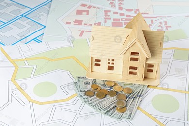 Money and house model on cadastral maps Photo of Money and house model on cadastral maps