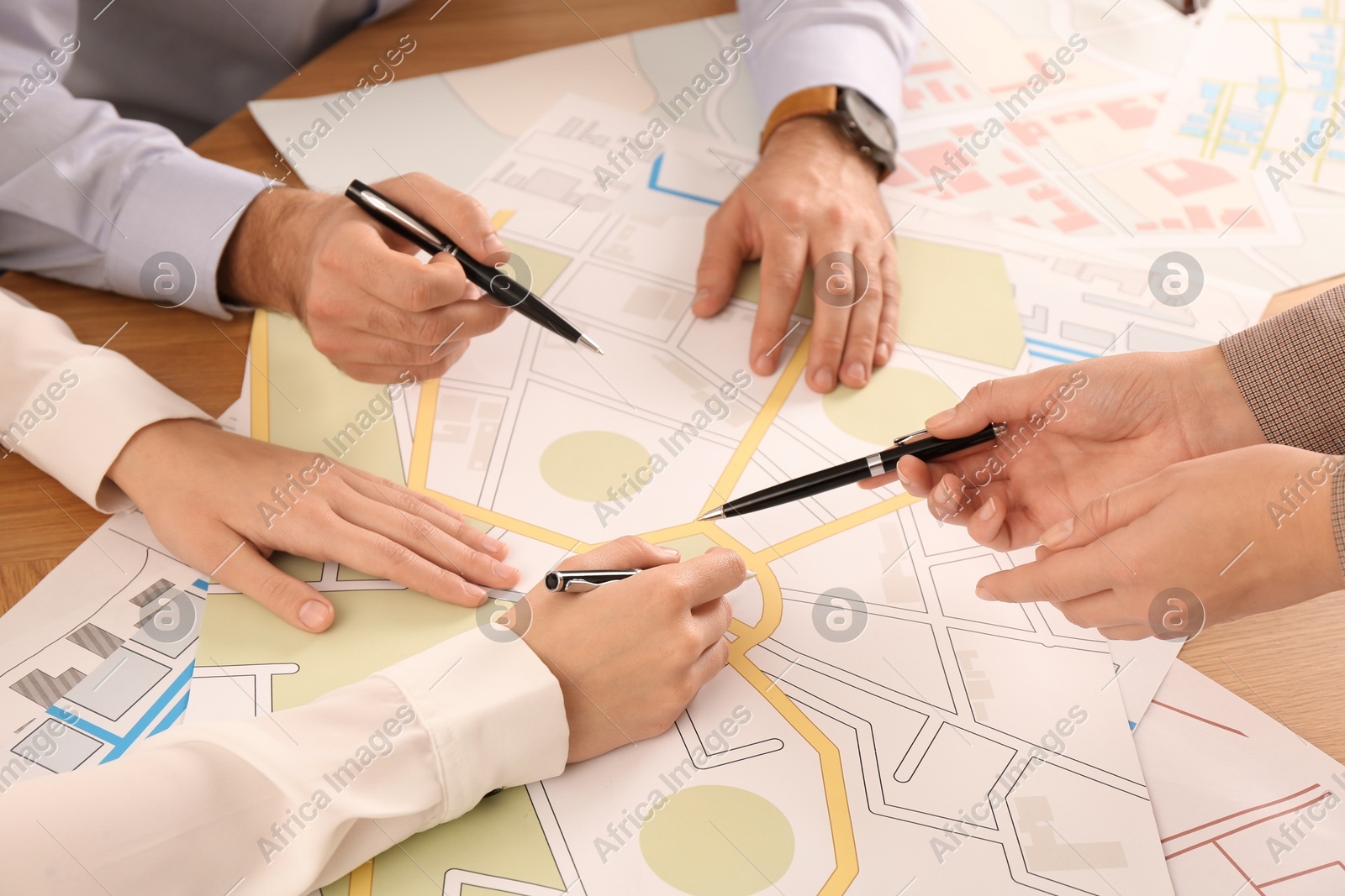 Professional cartographers working with cadastral map at table, closeup Photo of Professional cartographers working with cadastral map at table, closeup