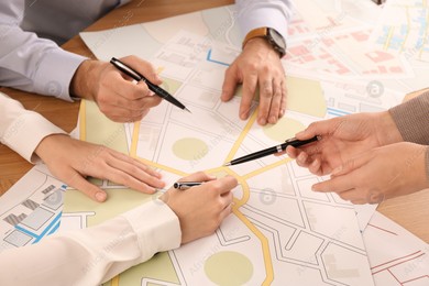 Professional cartographers working with cadastral map at table, closeup Photo of Professional cartographers working with cadastral map at table, closeup