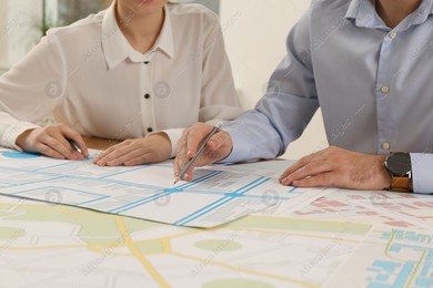 Professional cartographers working with cadastral map at table in office, closeup Photo of Professional cartographers working with cadastral map at table in office, closeup