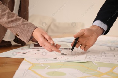 Professional cartographers working with cadastral map at table in office, closeup Photo of Professional cartographers working with cadastral map at table in office, closeup